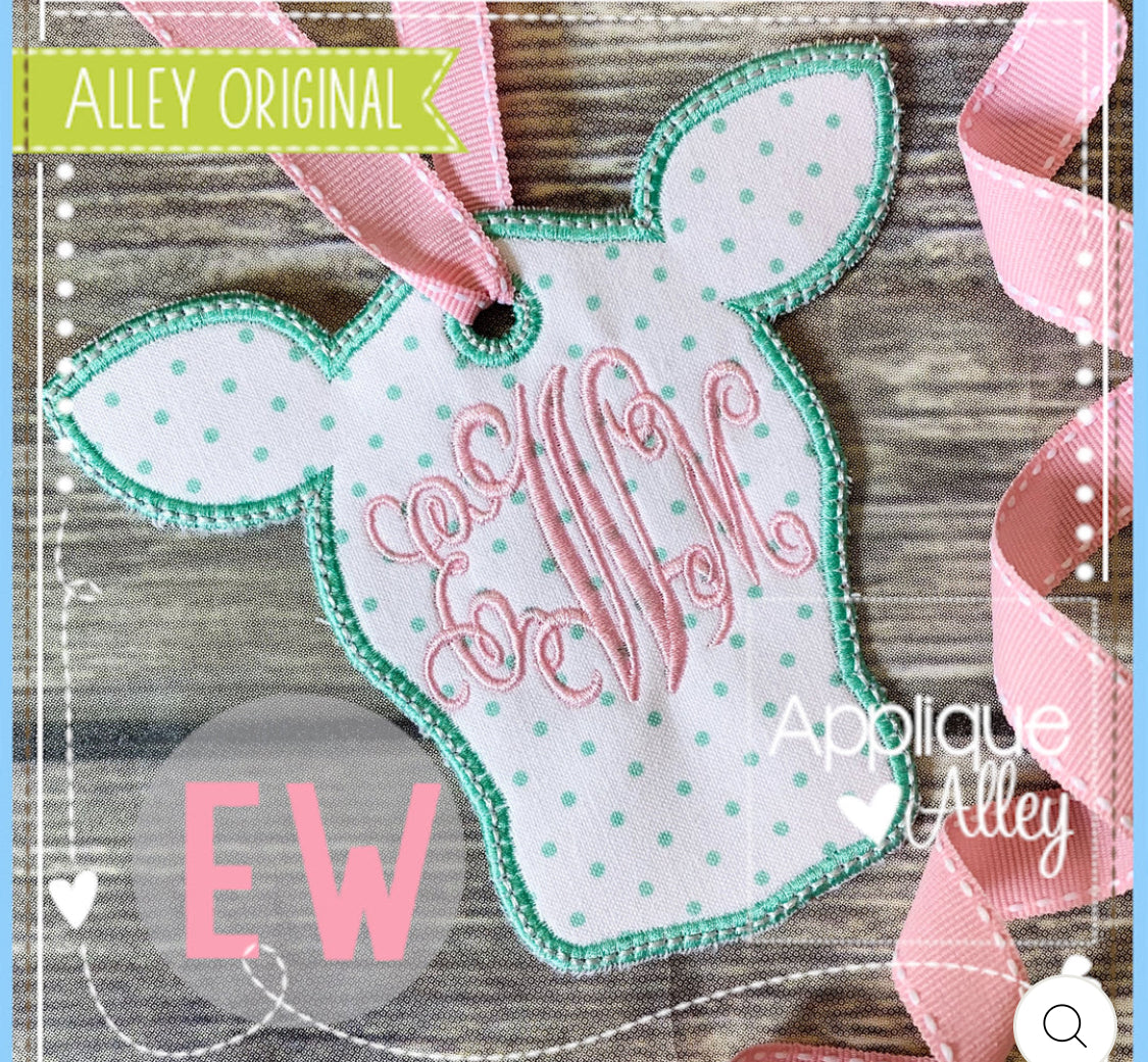 Decorative tag with polka dots and text on a wooden surface, featuring 'Applique Alley' branding.