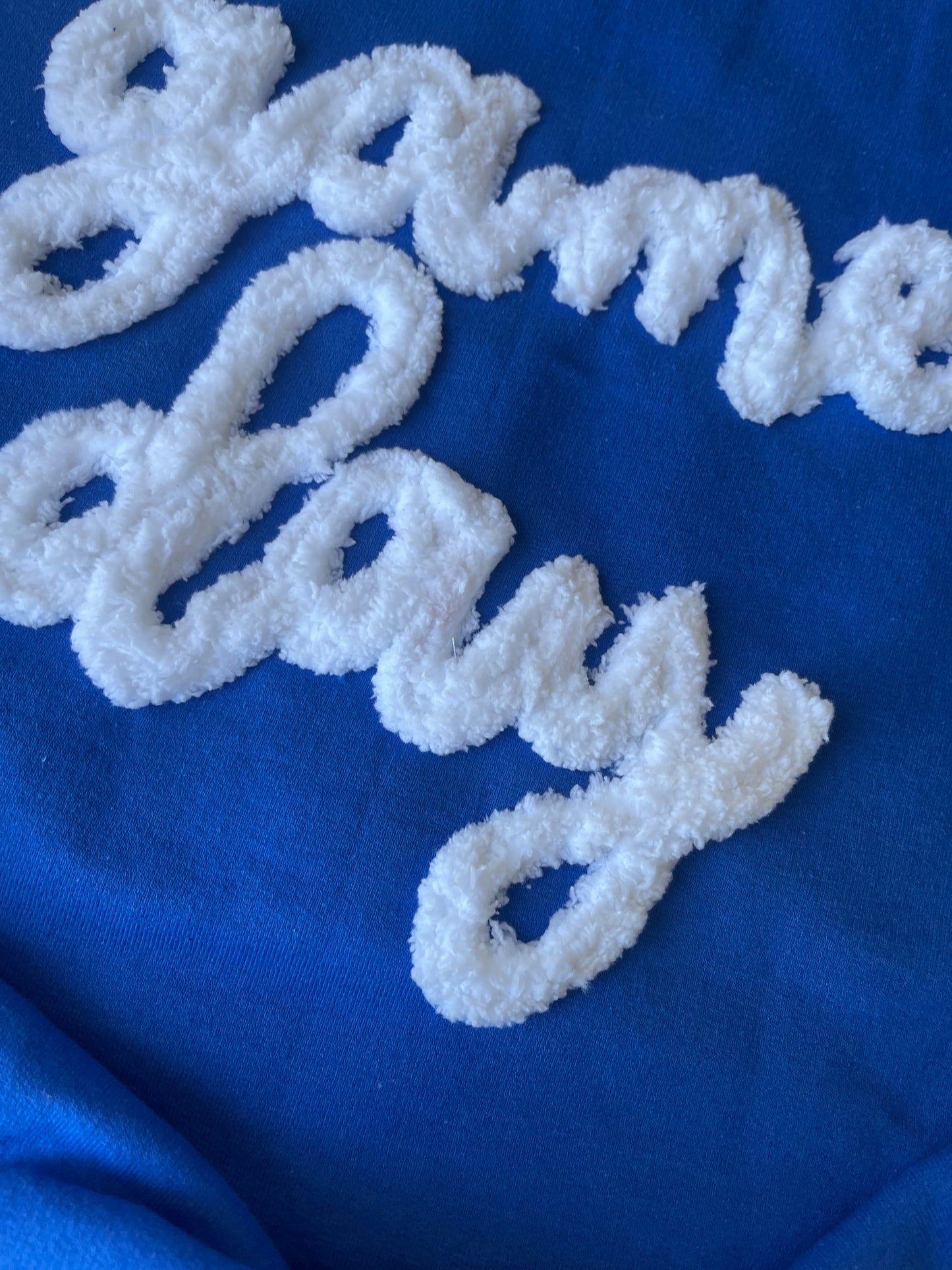 White embroidered text on a blue fabric background