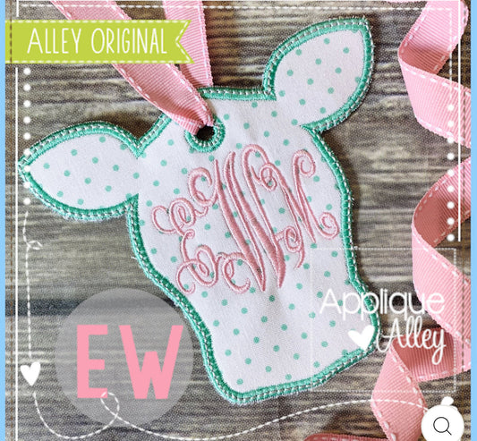 Decorative tag with polka dots and text on a wooden surface, featuring 'Applique Alley' branding.
