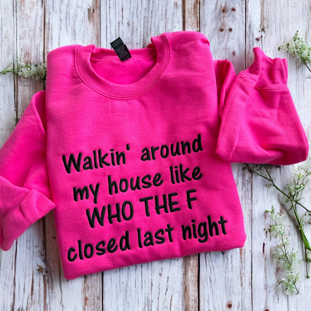 Pink sweatshirt with humorous text on a wooden surface