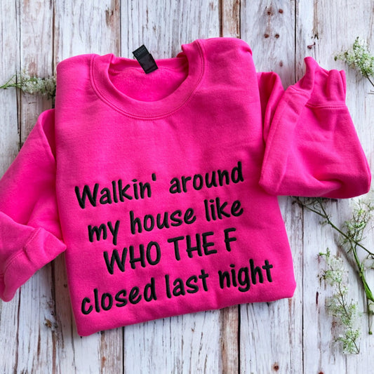 Pink sweatshirt with humorous text on a wooden surface