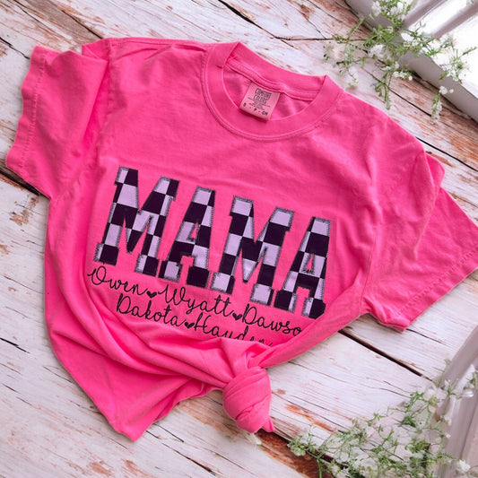 Pink t-shirt with 'MAMA' print on a wooden surface