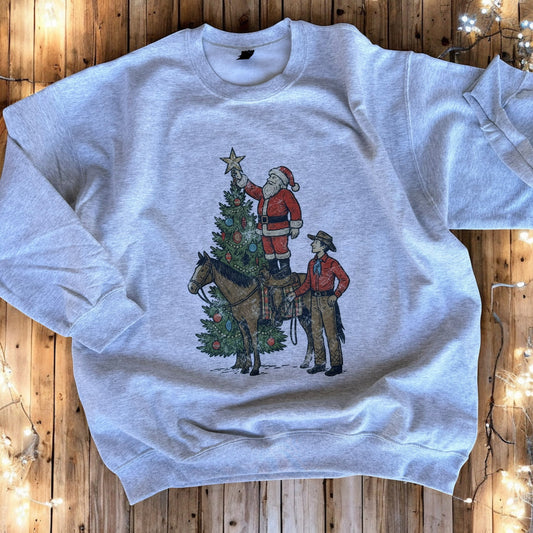 Gray sweatshirt with a Christmas design of Santa and a horse on a wooden surface.