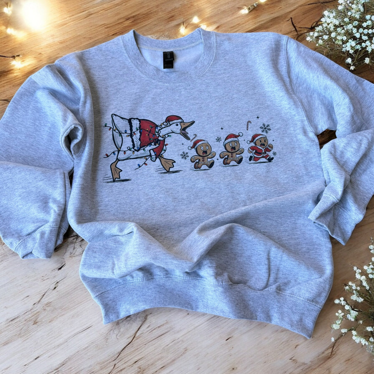 Gray sweatshirt with Christmas design on a wooden surface